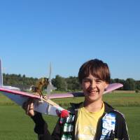 Student poses with plane he made at STEPS 2026